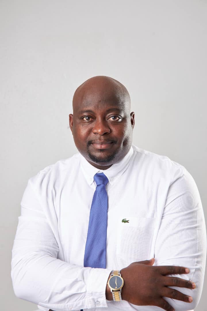 Bernard Amofa Jantuah in a white shirt and blue tie, looking directly at the camera